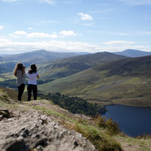 two girls taking a photo of the lake